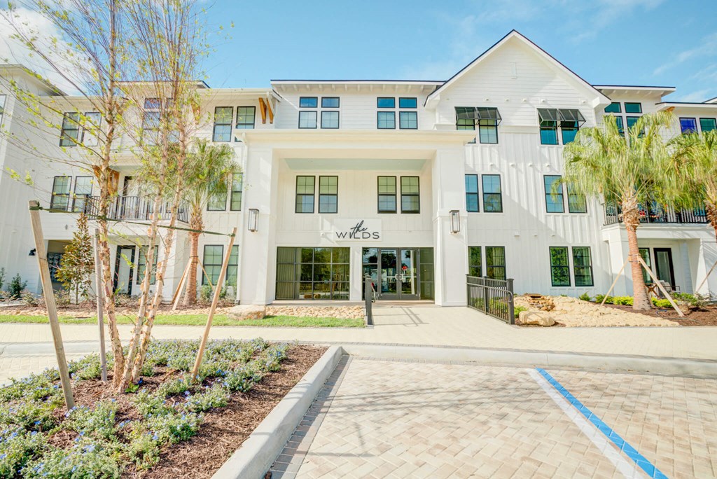 a large white building with a sidewalk in front of it