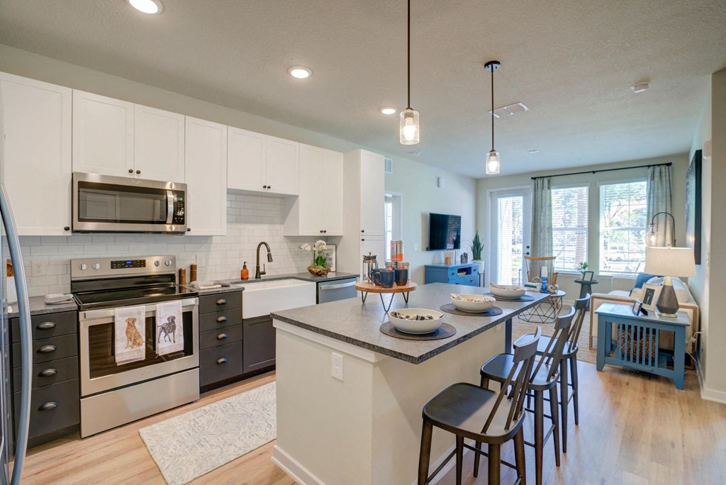 an open kitchen and dining area with a large island and chairs