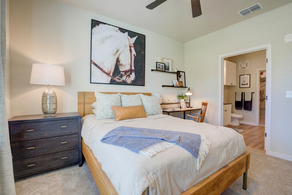 a bedroom with a bed and a painting of a horse