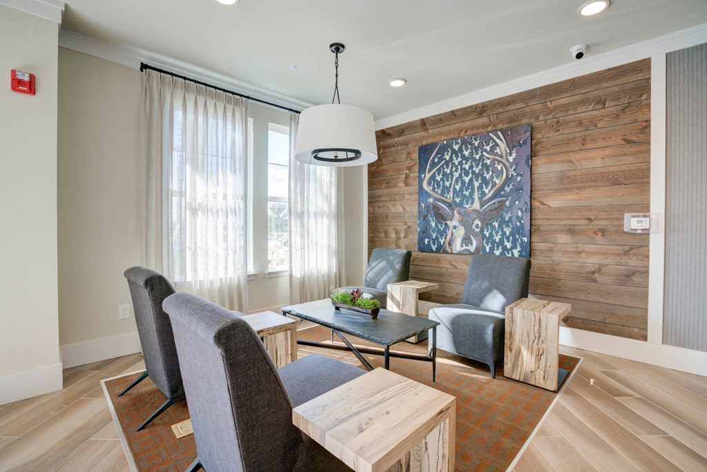 a living room with a wooden wall and a table and chairs