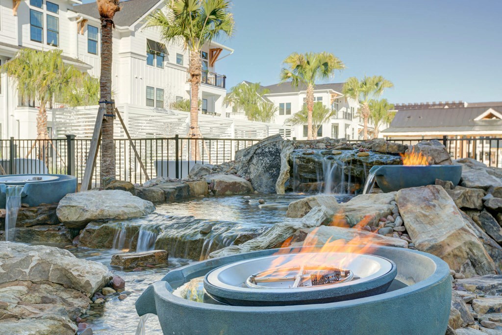 a backyard with a fire pit and waterfalls