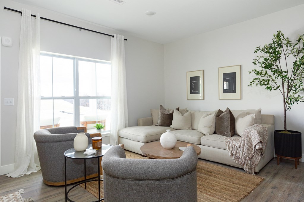 a living room with a couch and chairs and a large window