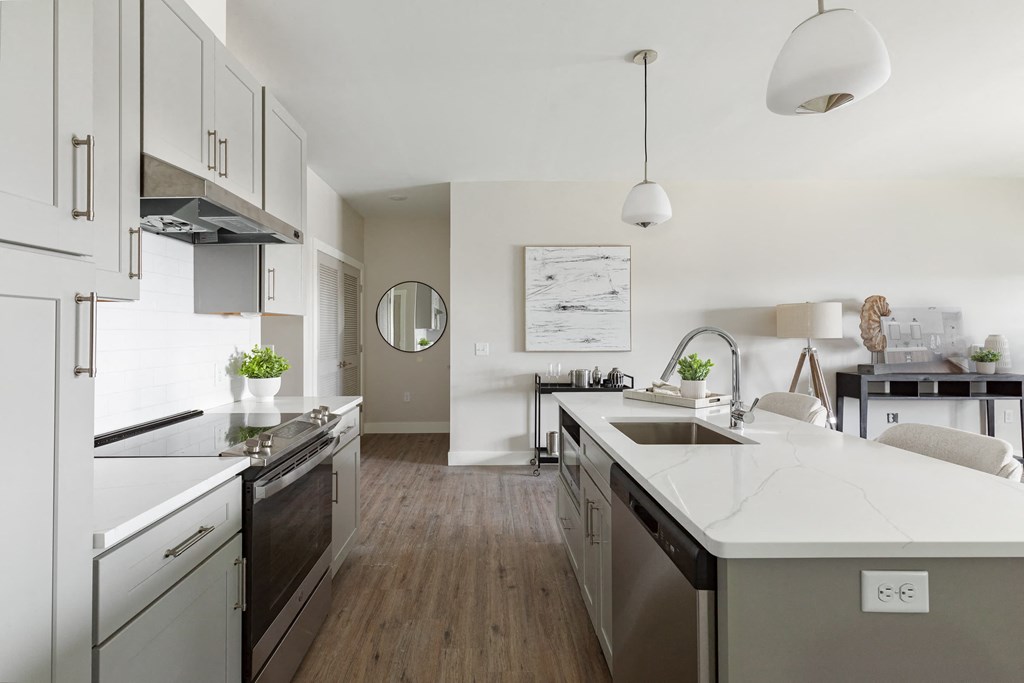 a kitchen with an island and a stove and a sink