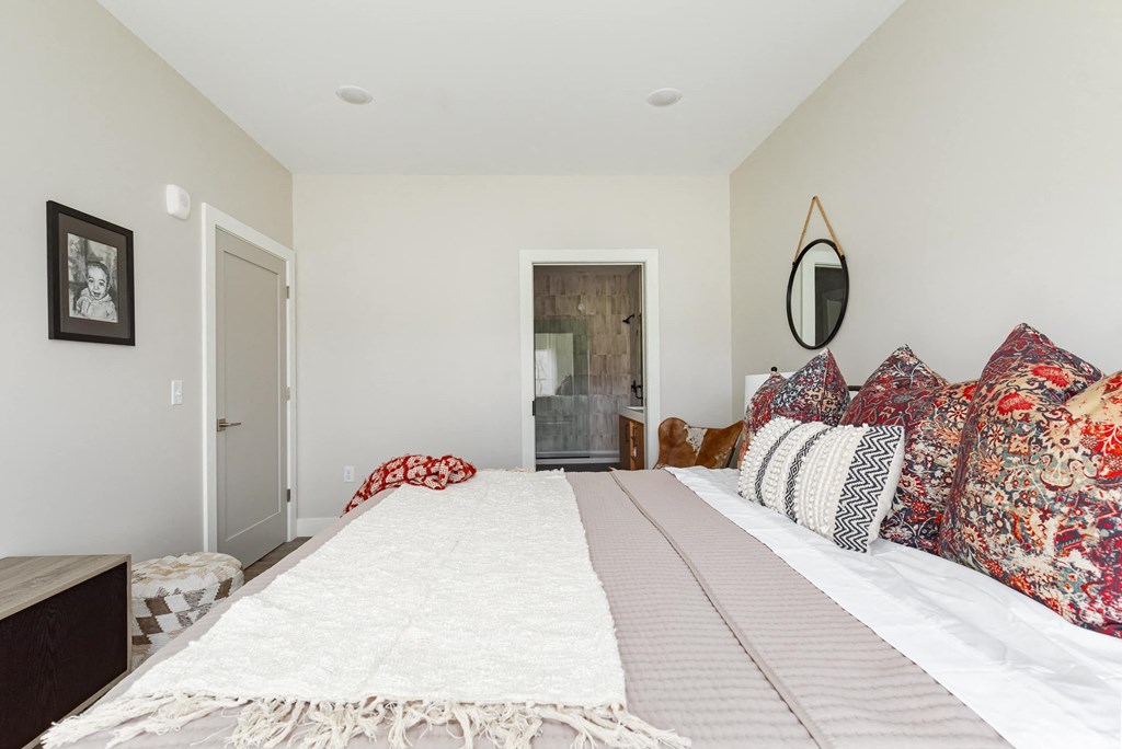 a bedroom with a large bed and a door to a bathroom