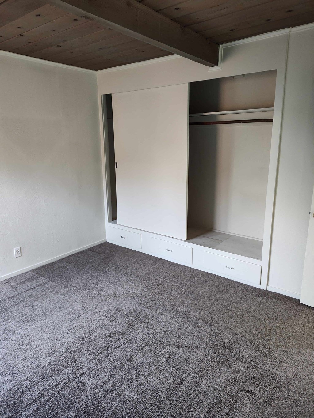 an empty room with white walls and a closet