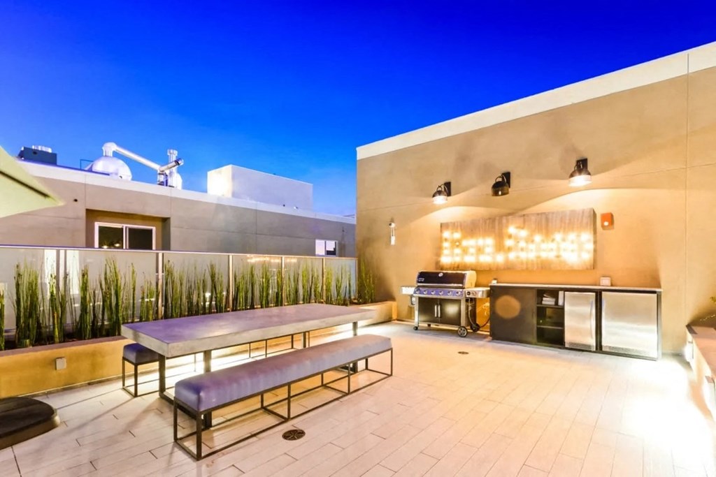 the patio has a grill and a table with benches