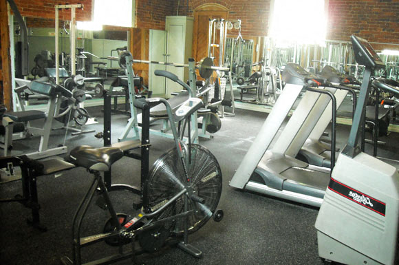 a gym with various machines and bikes in it