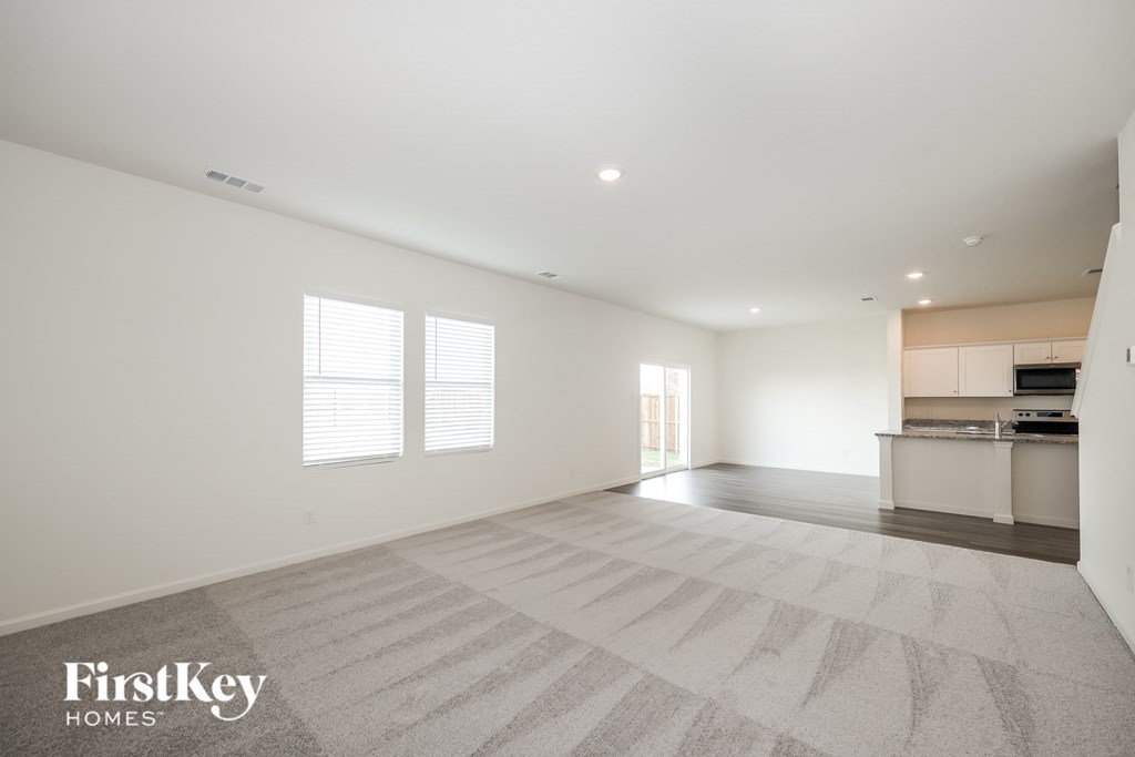 the living room and kitchen of a new home with white walls and flooring