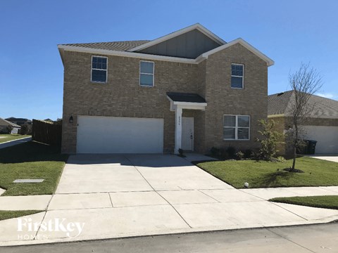 a tan brick house with a white garage door