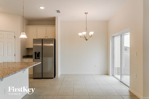 A kitchen with granite countertops and a refrigerator.