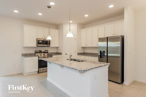 a large kitchen with white cabinets and granite counter tops