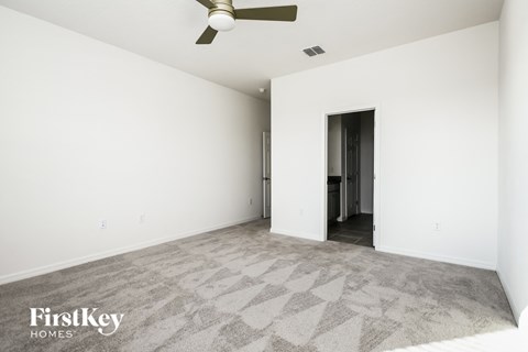 an empty living room with white walls and a ceiling fan