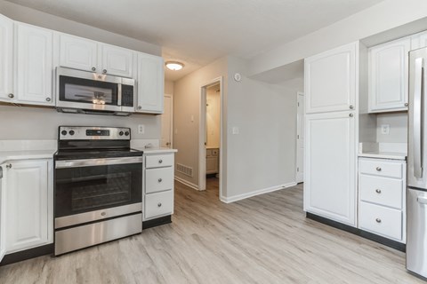 a renovated kitchen with white cabinets and stainless steel appliances