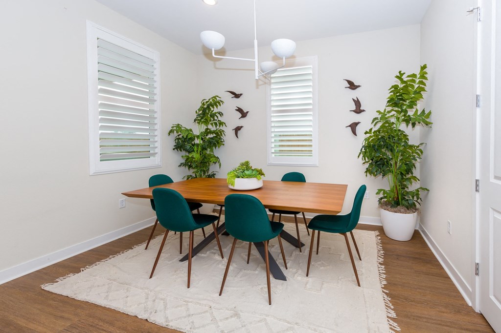 a dining room with a wooden table and green chairs
