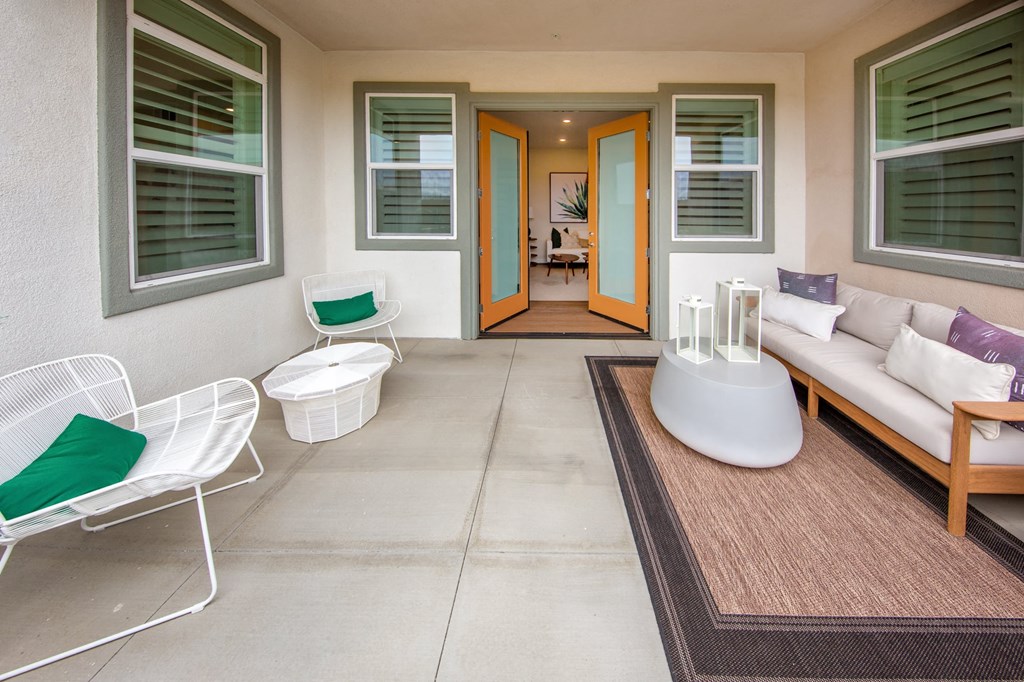 a porch with a couch and chairs and a table