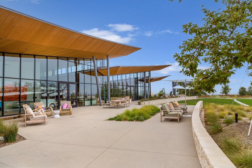 a patio with chairs and tables outside of a building