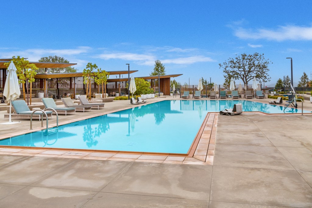 a swimming pool with chairs and umbrellas at the resort