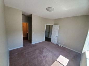 an empty living room with white walls and a wooden floor