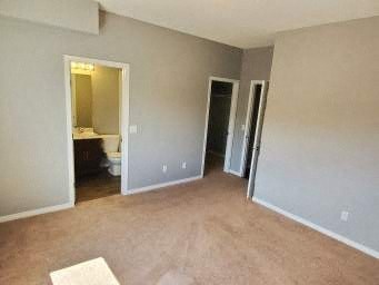 an empty living room with two doors and a bathroom