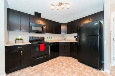 a kitchen with black appliances and black cabinets