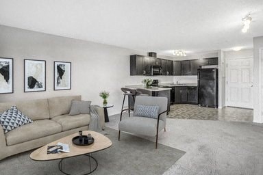 a living room and kitchen with a couch and chairs