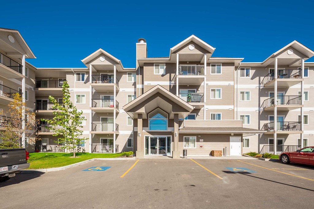 an empty parking lot in front of an apartment building