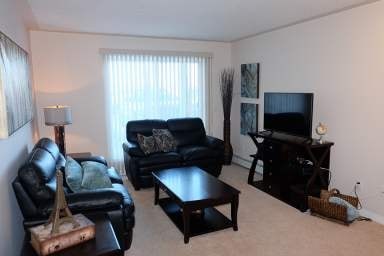 a living room with black leather furniture and a television