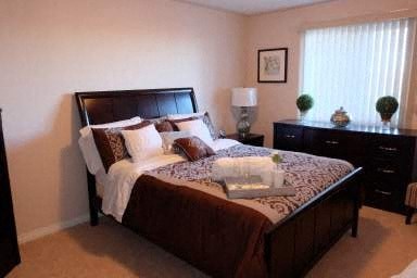 a bedroom with a bed and two dressers
