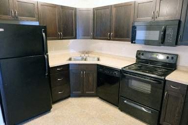 a kitchen with black appliances and black cabinets