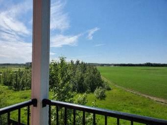 a view of a field and trees from a balcony