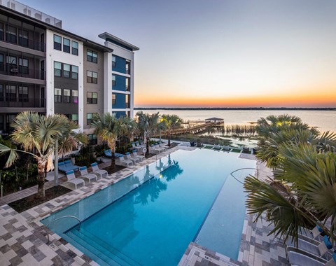 a swimming pool at the resort on the water at sunset