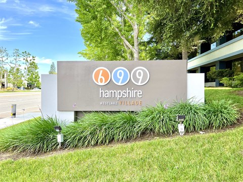 A sign for Hampshire Westlake Village is displayed in front of a building.