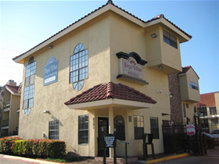 A small yellow building with a red tile roof.