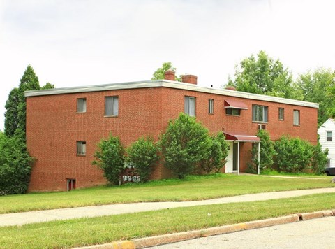 A red brick building with a white door and windows.