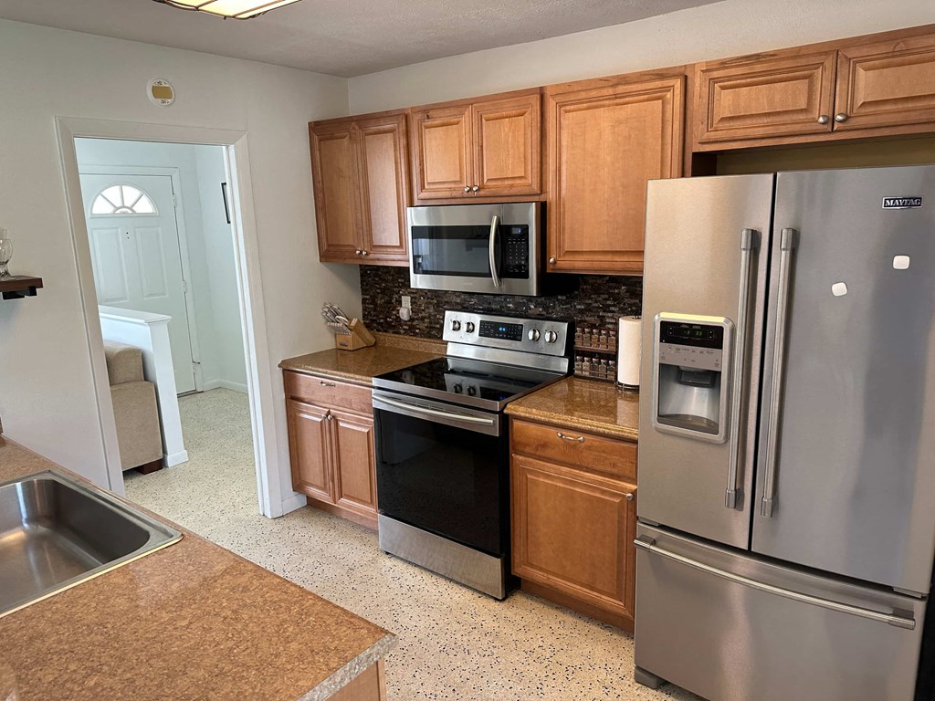 a kitchen with stainless steel appliances and wooden cabinets