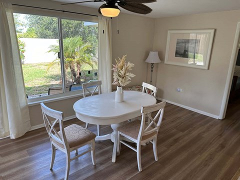 a dining room with a table and chairs and a large window