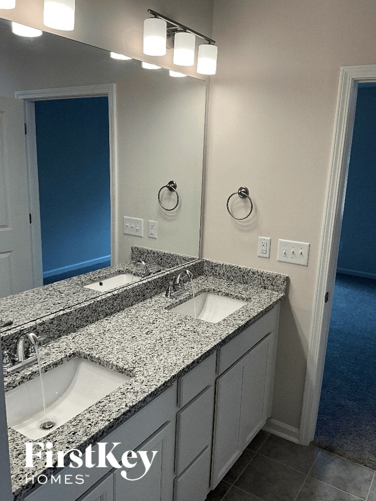 a bathroom with two sinks and granite counter tops