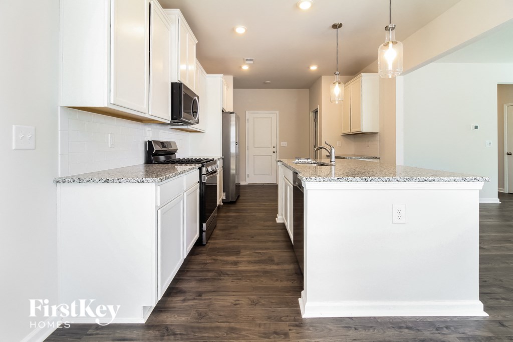 a white kitchen with white cabinets and a wood floor