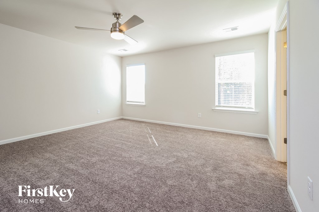 a bedroom with a carpeted floor and a ceiling fan