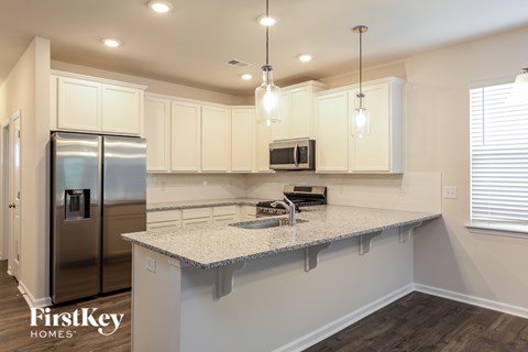 A kitchen with a refrigerator, microwave, and a countertop.