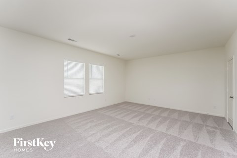 a white room with a carpeted floor and two windows
