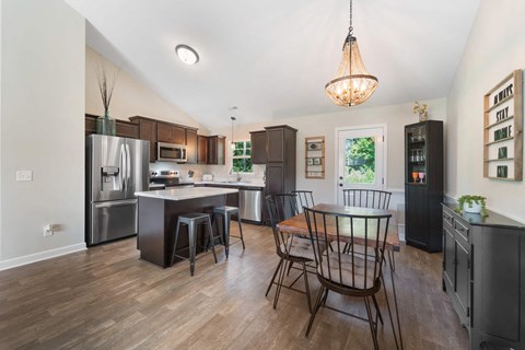 A kitchen with a table and chairs.