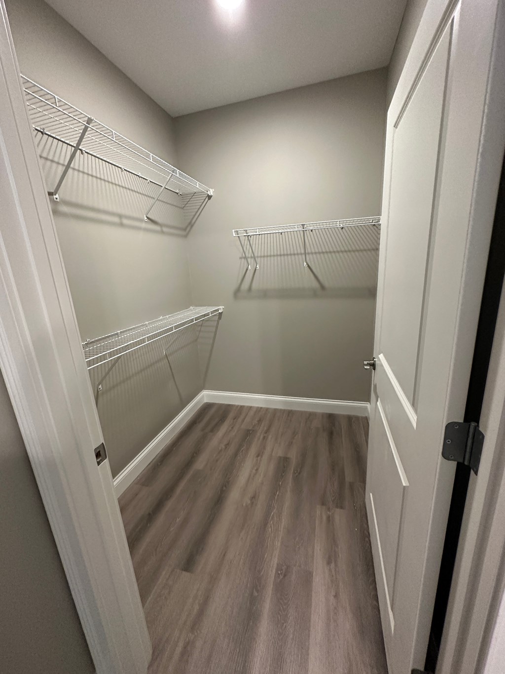 a walk in closet with two hanging racks and a door