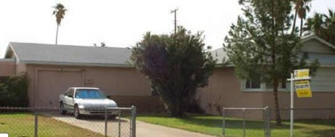 A house with a car parked in front of it.