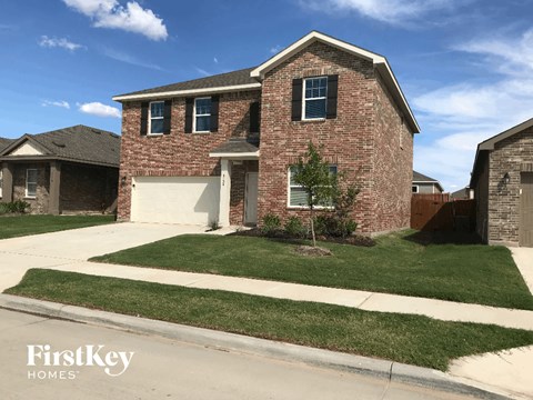 a brick house with a white garage door and a lawn