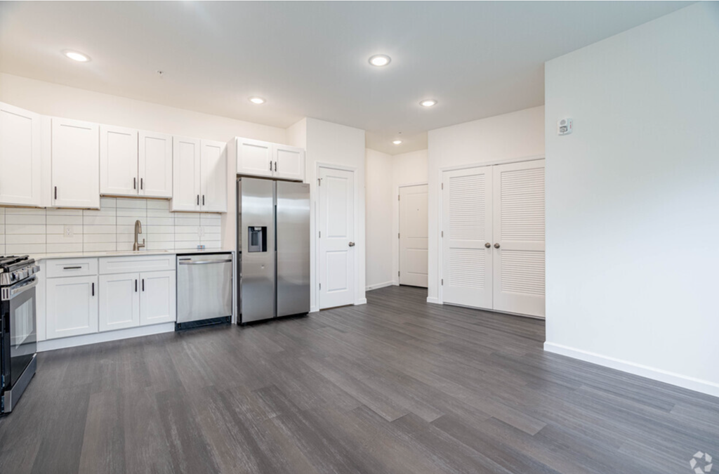 a renovated kitchen with white cabinets and stainless steel appliances