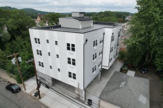 an aerial view of a white building with a black roof