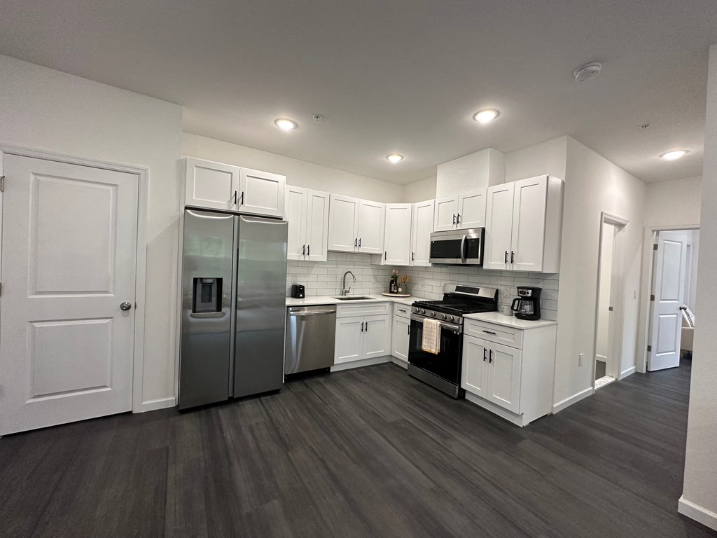 a kitchen with white cabinets and stainless steel appliances