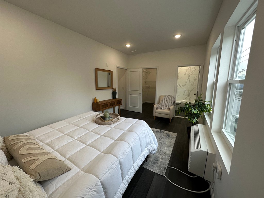 a bedroom with a large white bed and a large window