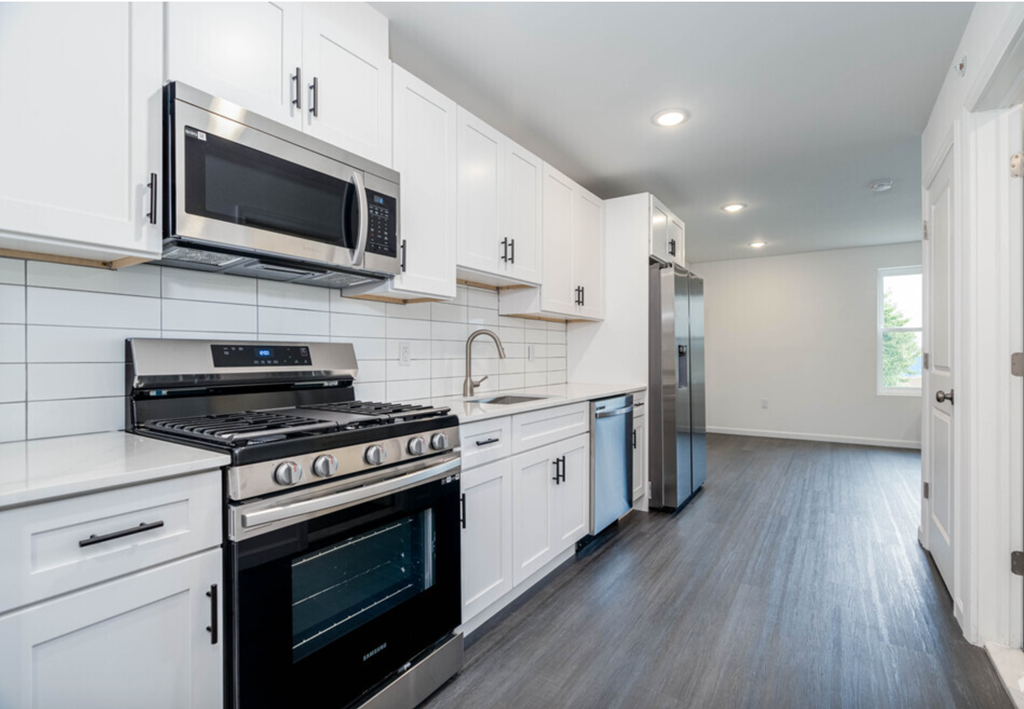 a kitchen with white cabinets and stainless steel appliances